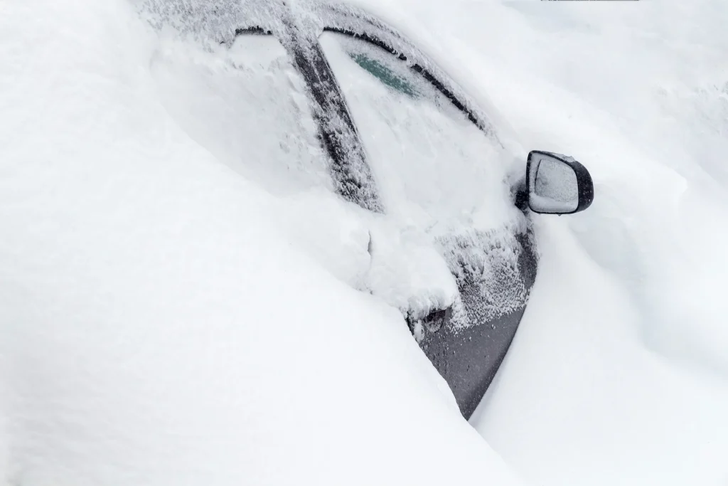 A car buried in deep snow in winter
